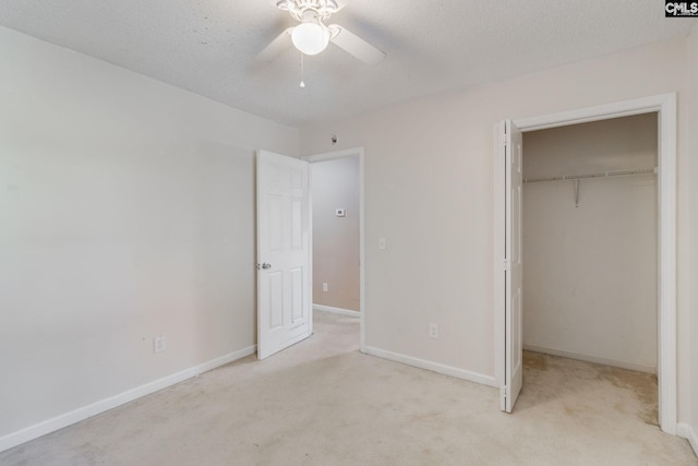 unfurnished bedroom with a textured ceiling, baseboards, a closet, and light colored carpet