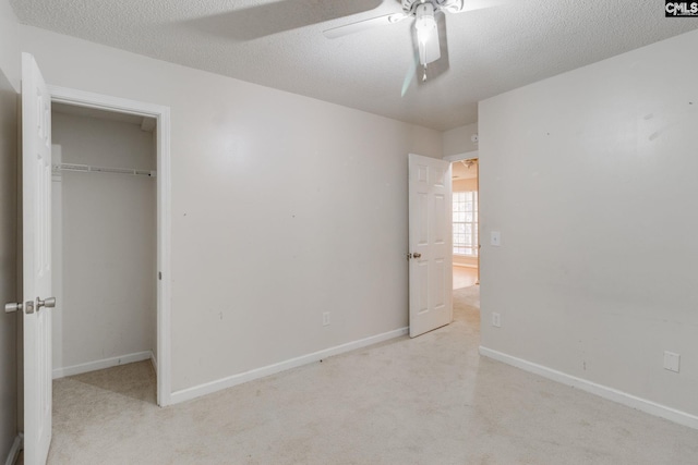 unfurnished bedroom with a closet, a textured ceiling, baseboards, and carpet flooring