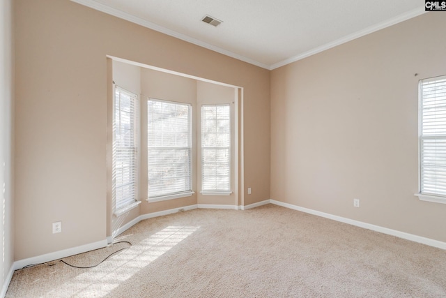 carpeted empty room featuring visible vents, crown molding, and baseboards