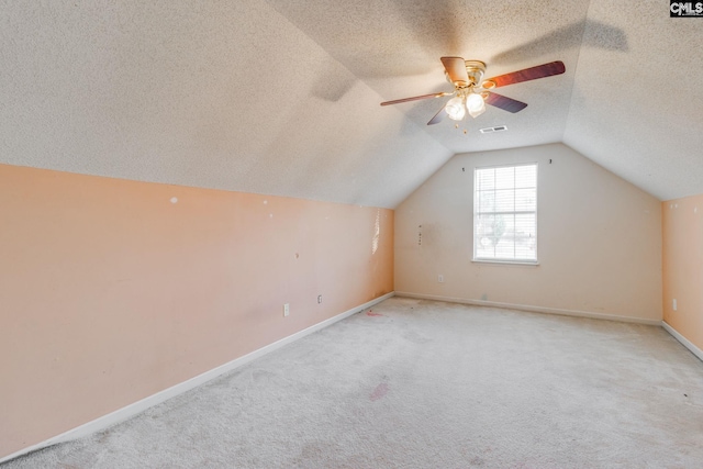 bonus room with lofted ceiling, visible vents, light carpet, and a textured ceiling