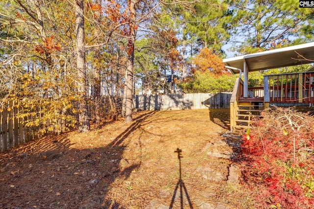 view of yard with a deck, stairway, and a fenced backyard