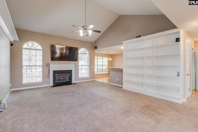 unfurnished living room with a fireplace with flush hearth, plenty of natural light, carpet floors, and ceiling fan