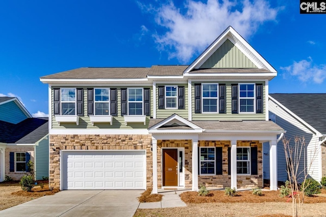 view of front of home featuring board and batten siding, stone siding, a porch, and driveway