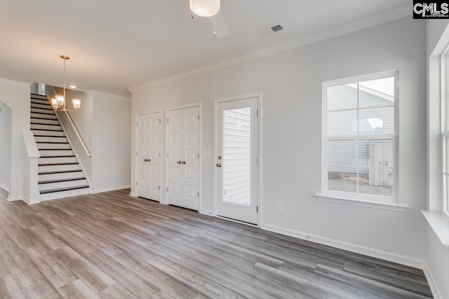 foyer with crown molding, stairway, baseboards, and wood finished floors