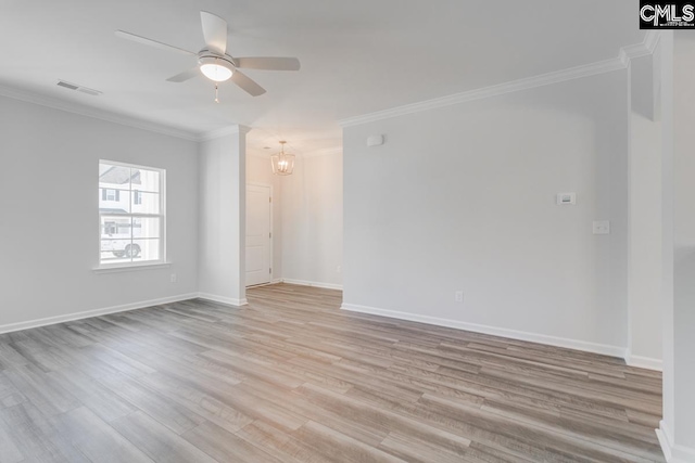 spare room with baseboards, light wood-style flooring, visible vents, and crown molding