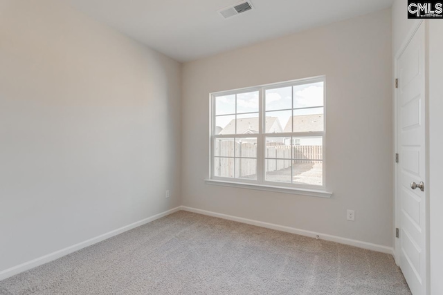 unfurnished room with carpet, visible vents, and baseboards