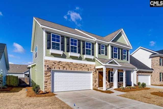 view of front of property featuring a garage, stone siding, fence, and concrete driveway