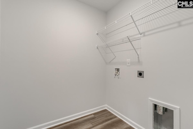 washroom with laundry area, baseboards, dark wood-type flooring, washer hookup, and electric dryer hookup