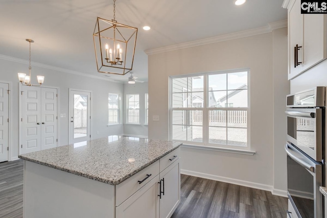 kitchen featuring dark wood-style flooring, double oven, ornamental molding, white cabinets, and baseboards