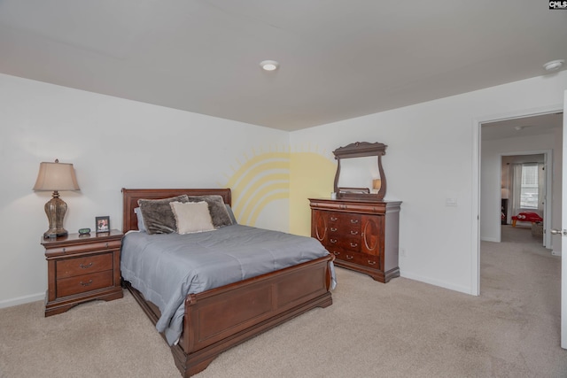 bedroom with light colored carpet and baseboards