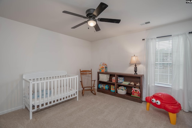 carpeted bedroom featuring baseboards, visible vents, and a ceiling fan