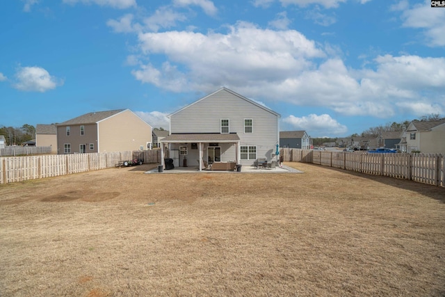 rear view of property with a yard, a patio area, and a fenced backyard