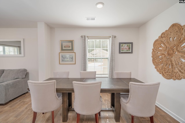 dining space featuring wood finished floors, visible vents, and baseboards