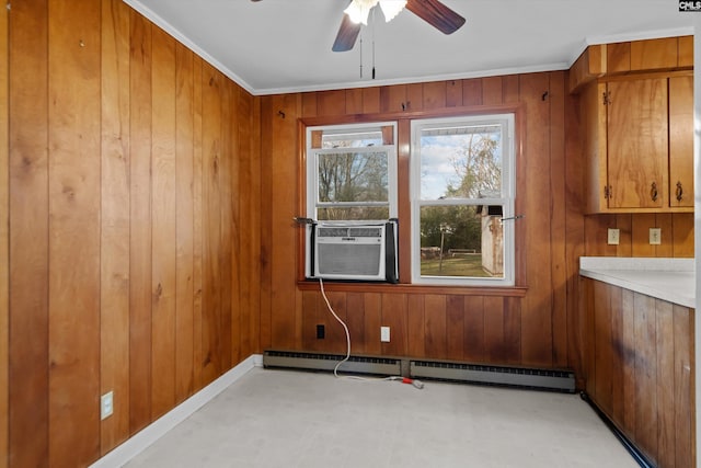 spare room with a baseboard heating unit, a ceiling fan, wooden walls, cooling unit, and baseboards