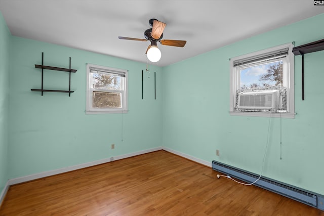 unfurnished room featuring cooling unit, wood finished floors, a ceiling fan, baseboards, and baseboard heating