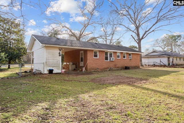 back of property with a yard, brick siding, crawl space, and fence