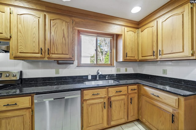 kitchen featuring backsplash, dark stone countertops, stainless steel appliances, and a sink