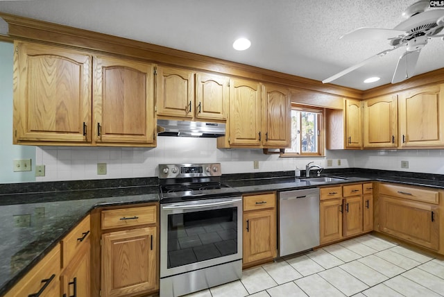 kitchen featuring stainless steel appliances, backsplash, a sink, and under cabinet range hood