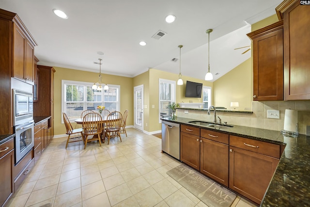 kitchen with stainless steel appliances, a sink, visible vents, decorative backsplash, and dark stone countertops