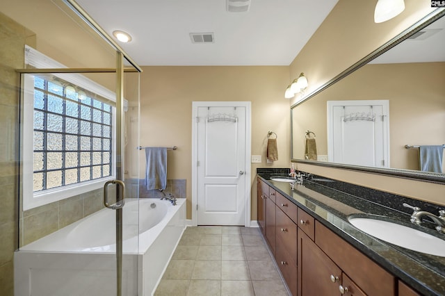 full bath featuring a garden tub, tile patterned flooring, a sink, and visible vents