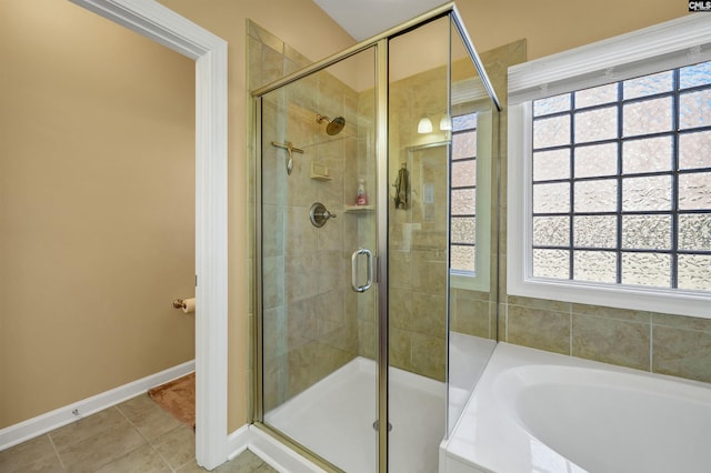 bathroom with baseboards, a stall shower, a garden tub, and tile patterned floors