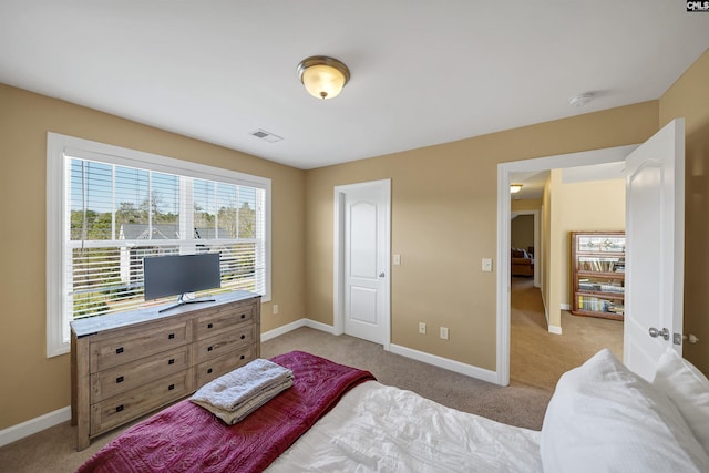 bedroom featuring baseboards, visible vents, and light colored carpet