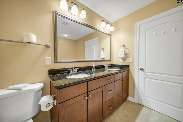 full bath with double vanity, tile patterned flooring, a sink, and toilet