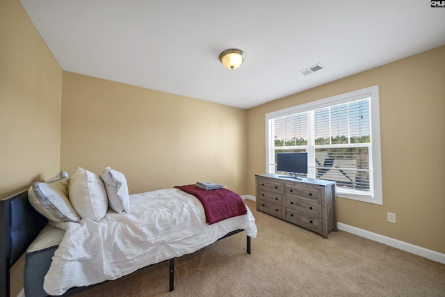 bedroom with baseboards, visible vents, and light colored carpet