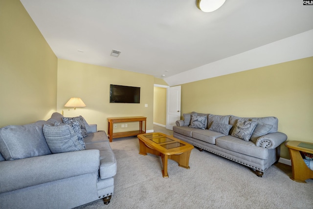 carpeted living area with visible vents, vaulted ceiling, and baseboards