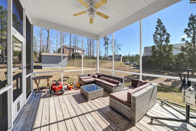 sunroom featuring a ceiling fan and plenty of natural light