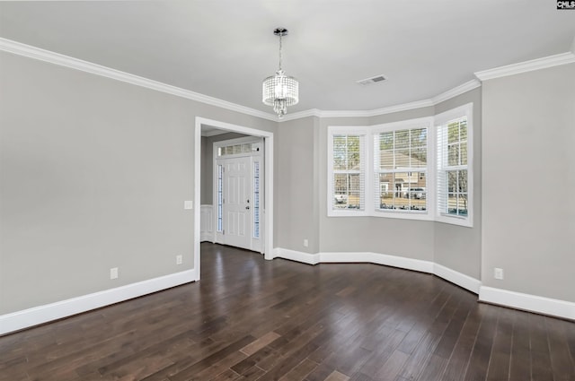 empty room featuring a notable chandelier, crown molding, baseboards, and wood finished floors