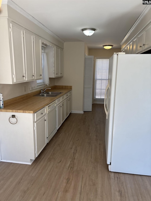 kitchen with white cabinetry, white appliances, wood finished floors, and a sink