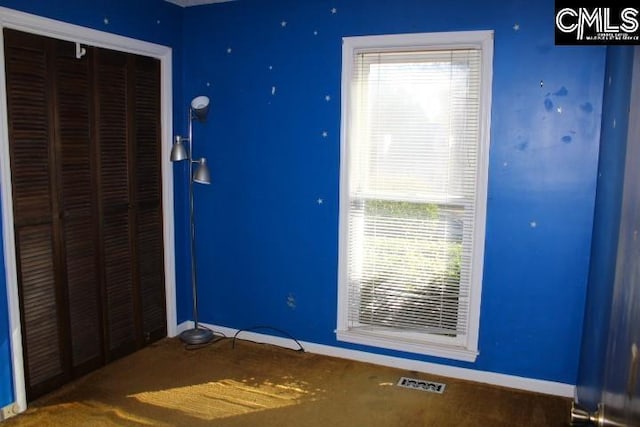 unfurnished bedroom with a closet, visible vents, and baseboards