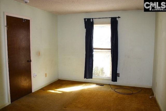 unfurnished room featuring carpet floors and a textured ceiling