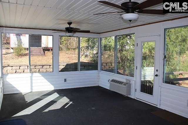 unfurnished sunroom with ceiling fan and an AC wall unit