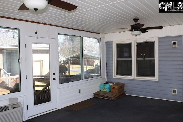 unfurnished sunroom featuring a wall mounted air conditioner and a ceiling fan