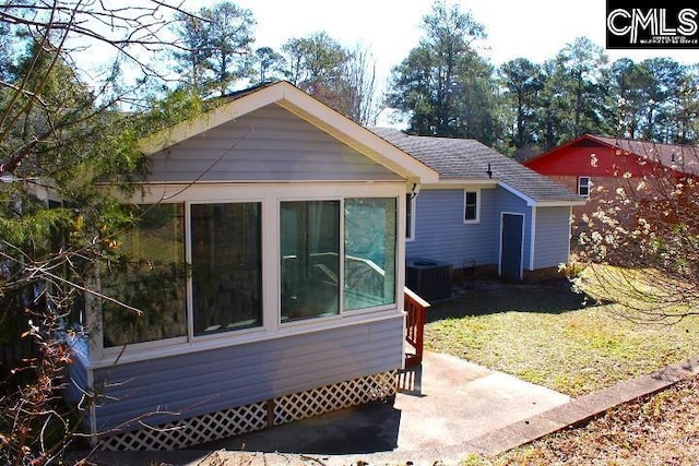 rear view of property with a shingled roof and central air condition unit