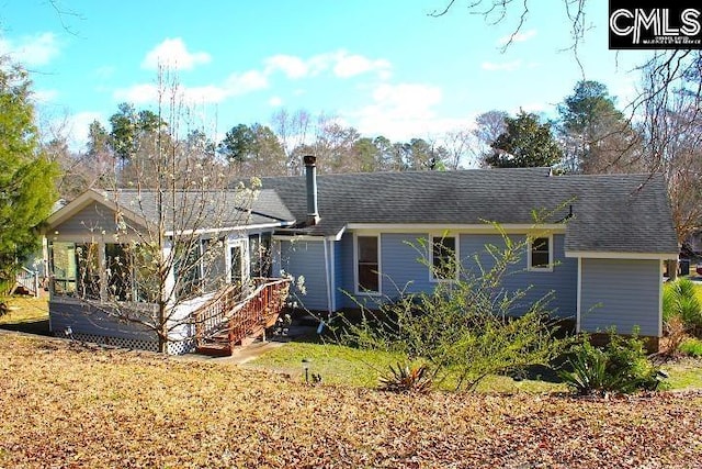 rear view of property featuring roof with shingles