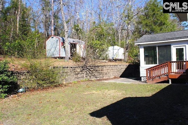 view of yard featuring a sunroom, a shed, and an outbuilding