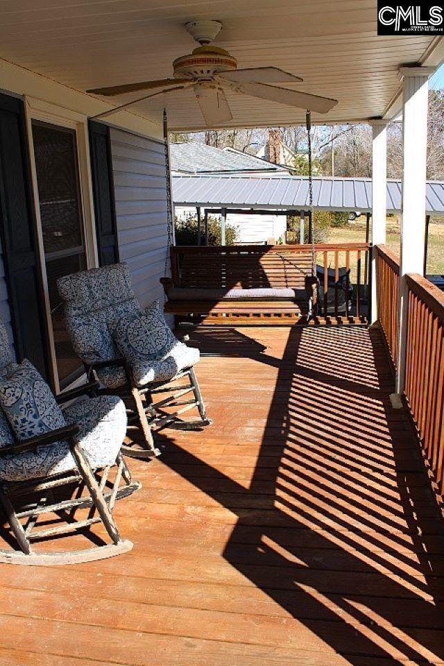 wooden deck featuring covered porch and a ceiling fan