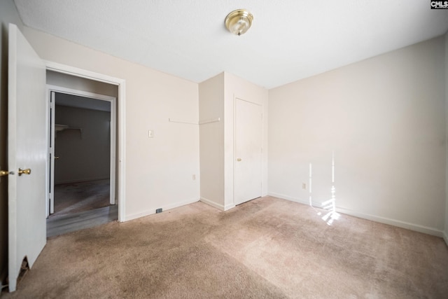 unfurnished bedroom with a closet, carpet flooring, and baseboards