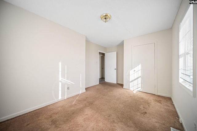 unfurnished bedroom with carpet flooring and baseboards