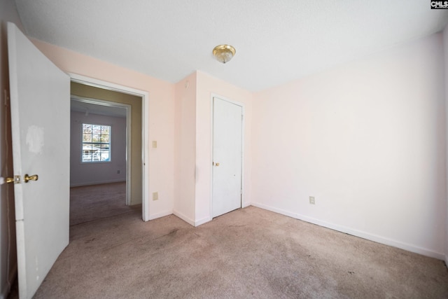 unfurnished bedroom with a closet, carpet flooring, and baseboards