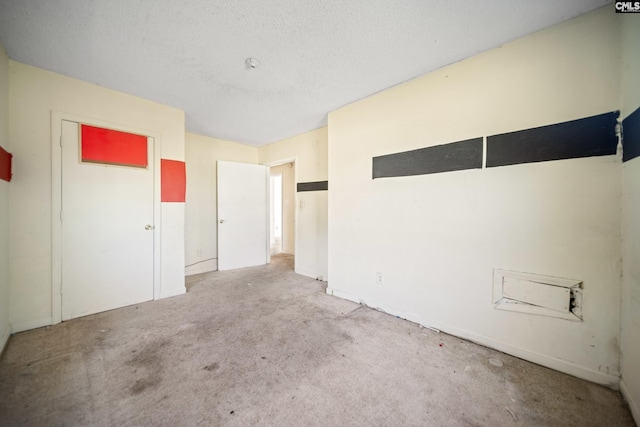 unfurnished room featuring light carpet and a textured ceiling