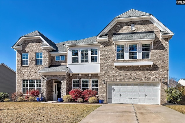 view of front of home with an attached garage, brick siding, concrete driveway, roof with shingles, and a front yard