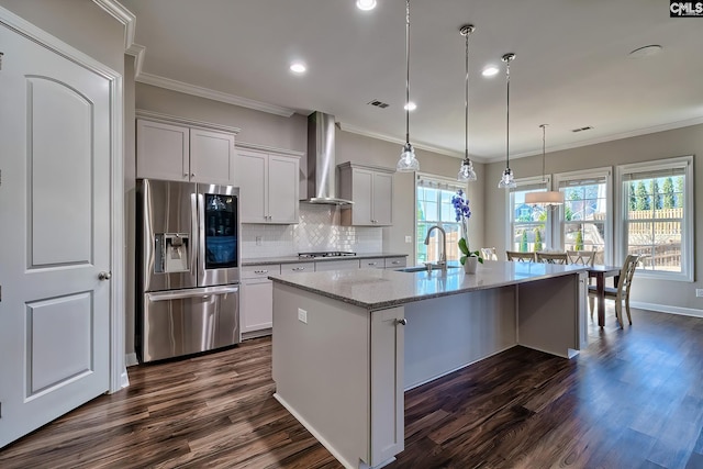 kitchen with stainless steel appliances, wall chimney exhaust hood, a sink, and crown molding