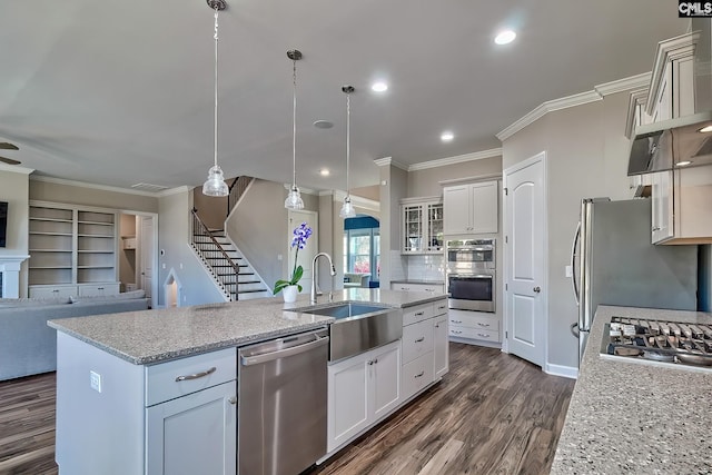 kitchen with appliances with stainless steel finishes, dark wood finished floors, open floor plan, and crown molding