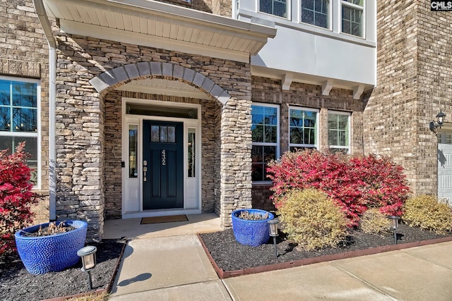 property entrance featuring stone siding and brick siding