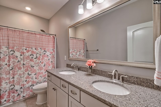 bathroom featuring double vanity, tile patterned flooring, a sink, and toilet