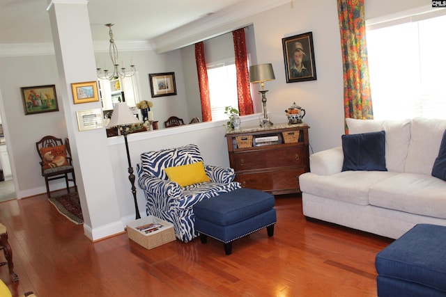 living area with ornamental molding, baseboards, and wood finished floors